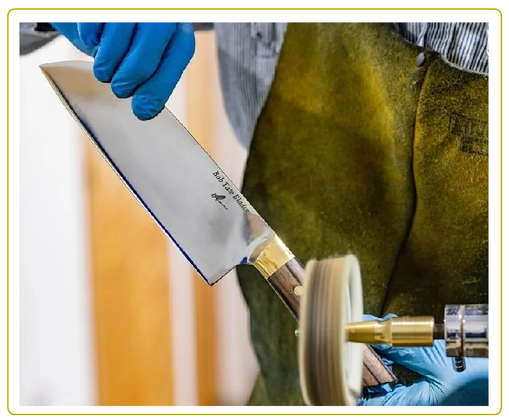 A person wearing blue gloves and holding a knife.