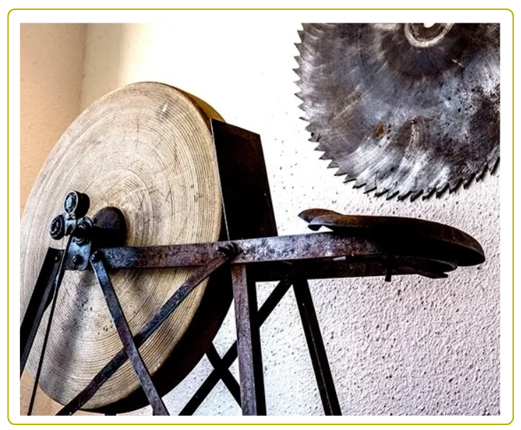 A large circular saw blade sitting on top of a wooden wheel.