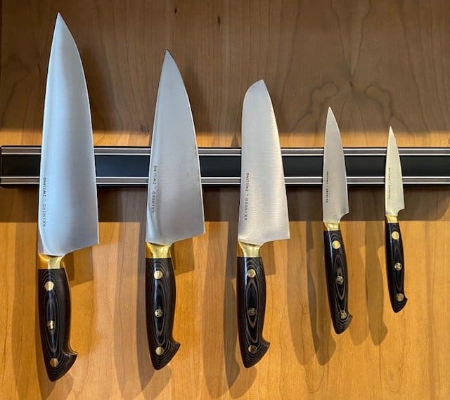 A row of knives hanging on the wall.