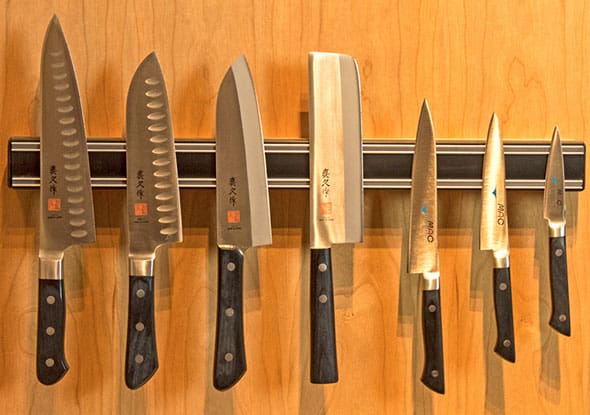 A row of knives hanging on the wall.