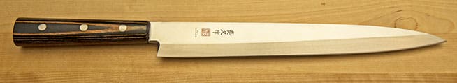 A close up of the blade of a japanese knife