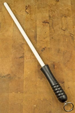 A wooden stick with a black handle on top of it.