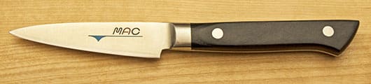 A knife with a black handle and white dots on it.