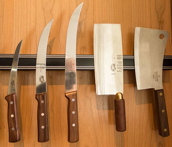 A set of knives hanging on the wall.