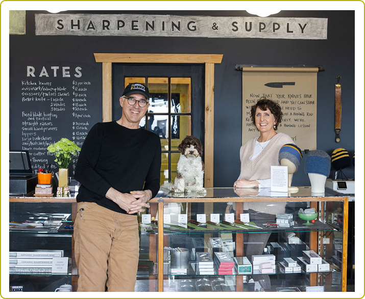 A man and woman standing in front of a store.